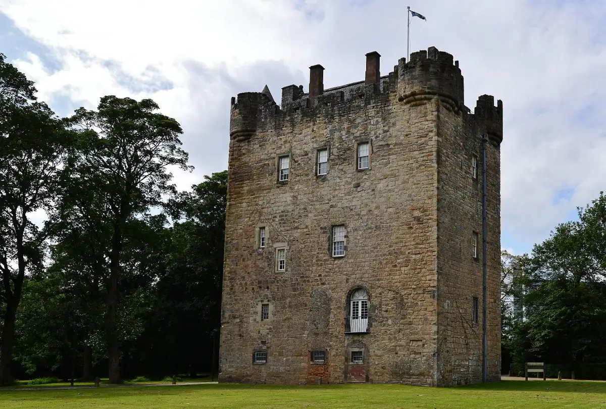 Front view of Alloa Tower with its crenellated top, framed by mature trees