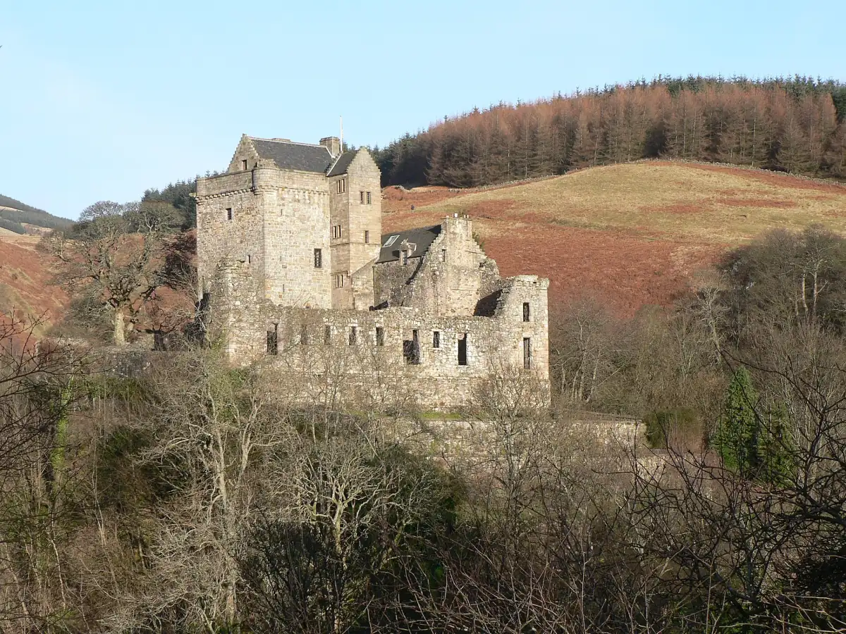 Castle Campbell above its wooded glen with rolling brown hills behind