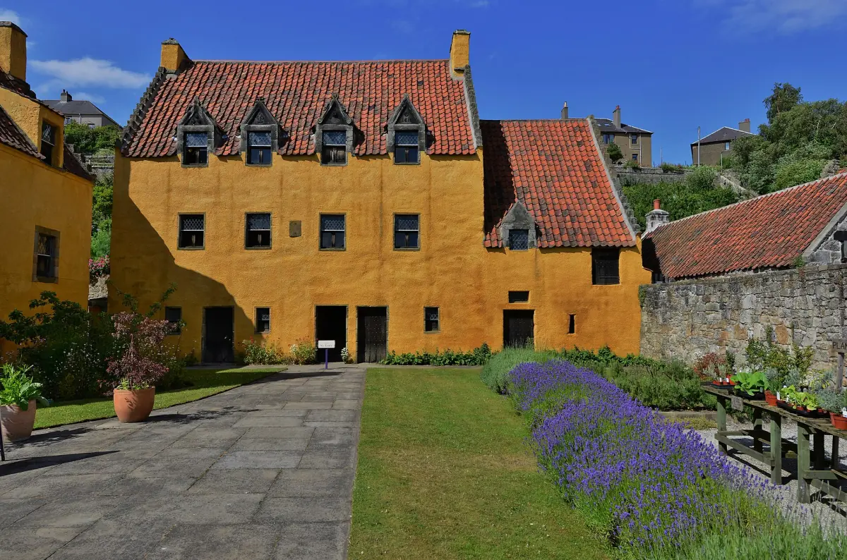 Classic view of Culross Palace from its herb garden under blue sky