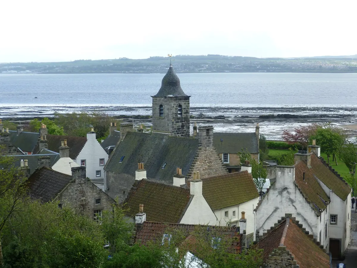 Whitewashed Culross rooftops and church tower above the Firth of Forth