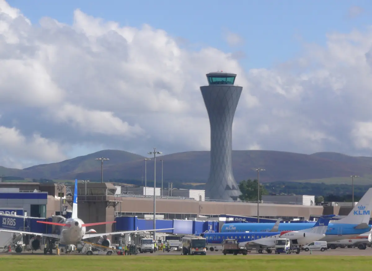 Edinburgh Airport control tower and aircraft with hills behind