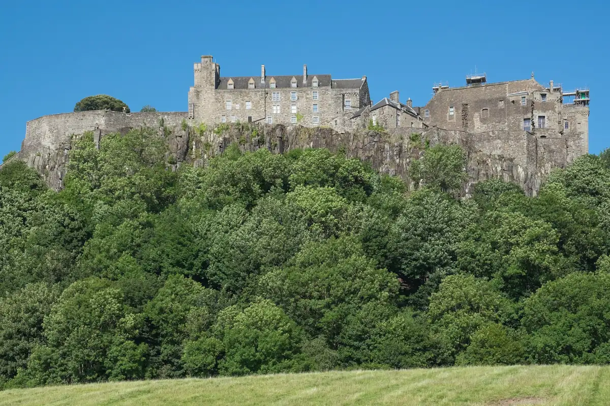 Stirling Castle on its rocky crag above green woodland