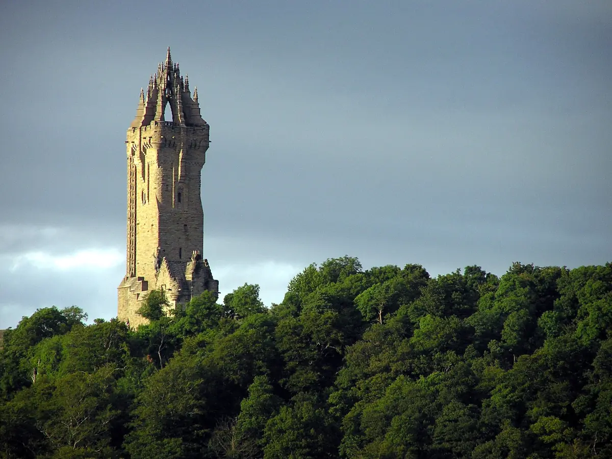 The tall Gothic tower of the Wallace Monument rising above dark trees